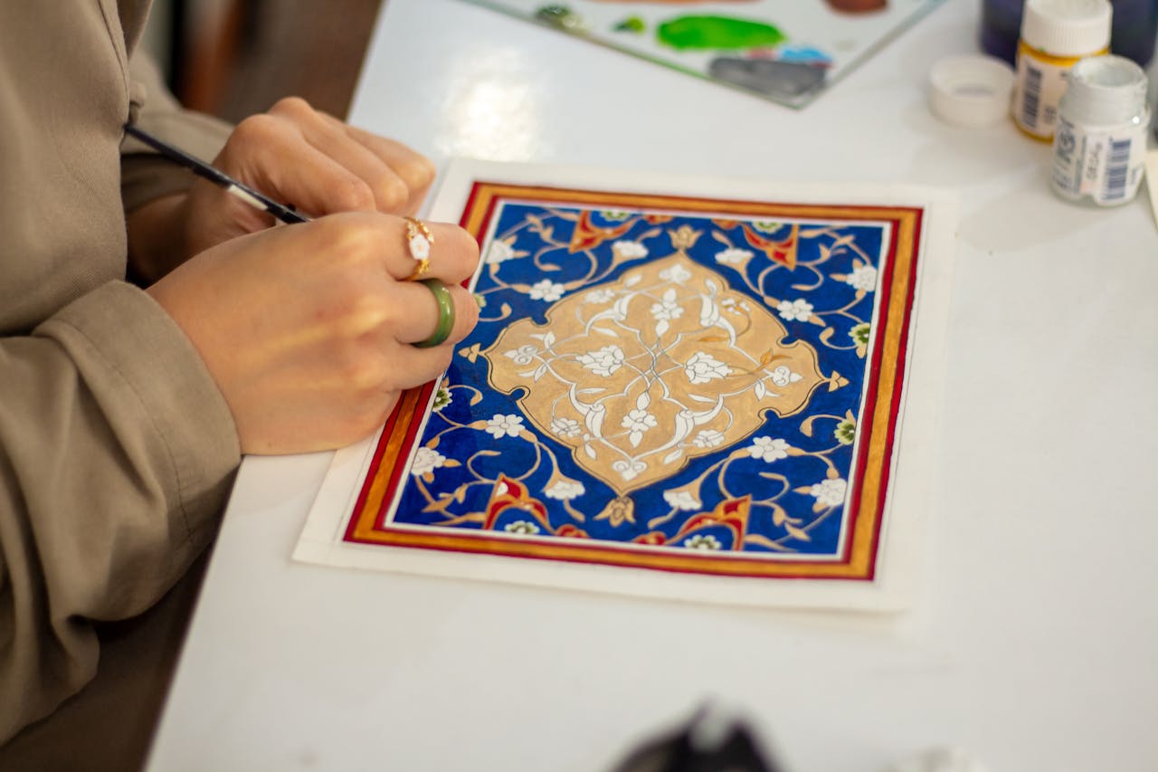 gallery-05 Close-up of an artist working on a traditional geometric design with intricate patterns.